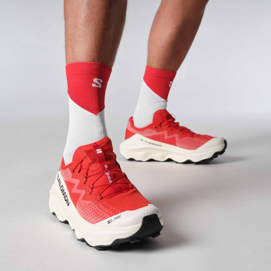 A model wearing a pair of Salomon Unisex S/LAB Ultra Glide Running Shoes in the Fiery Red colourway. (8576021921954)