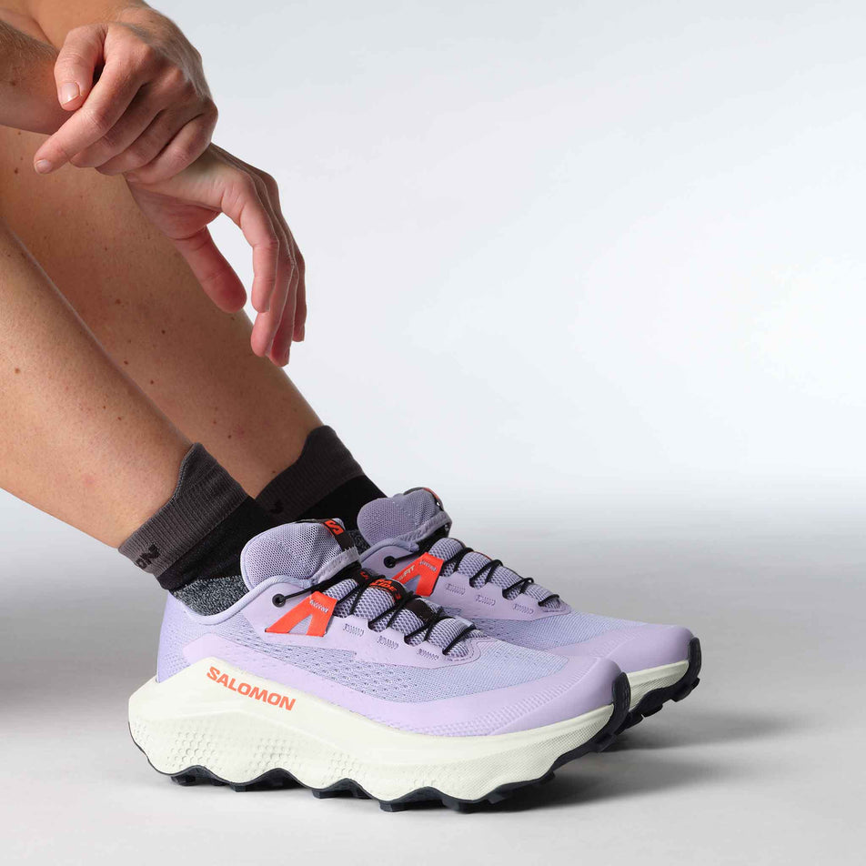 A model wearing a pair of Salomon Women's Ultra Glide 3 Running Shoes in the Cosmic Sky/Icicle/Neon Flame colourway. (8576019497122)