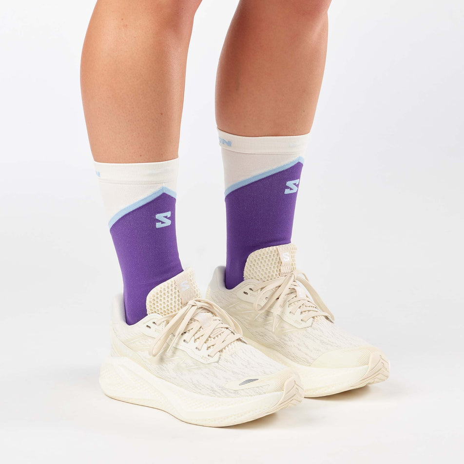 A model wearing a pair of Salomon Women's Aero Glide 4 Running Shoes in the Vanilla Ice/Vanilla Ice/White colourway.