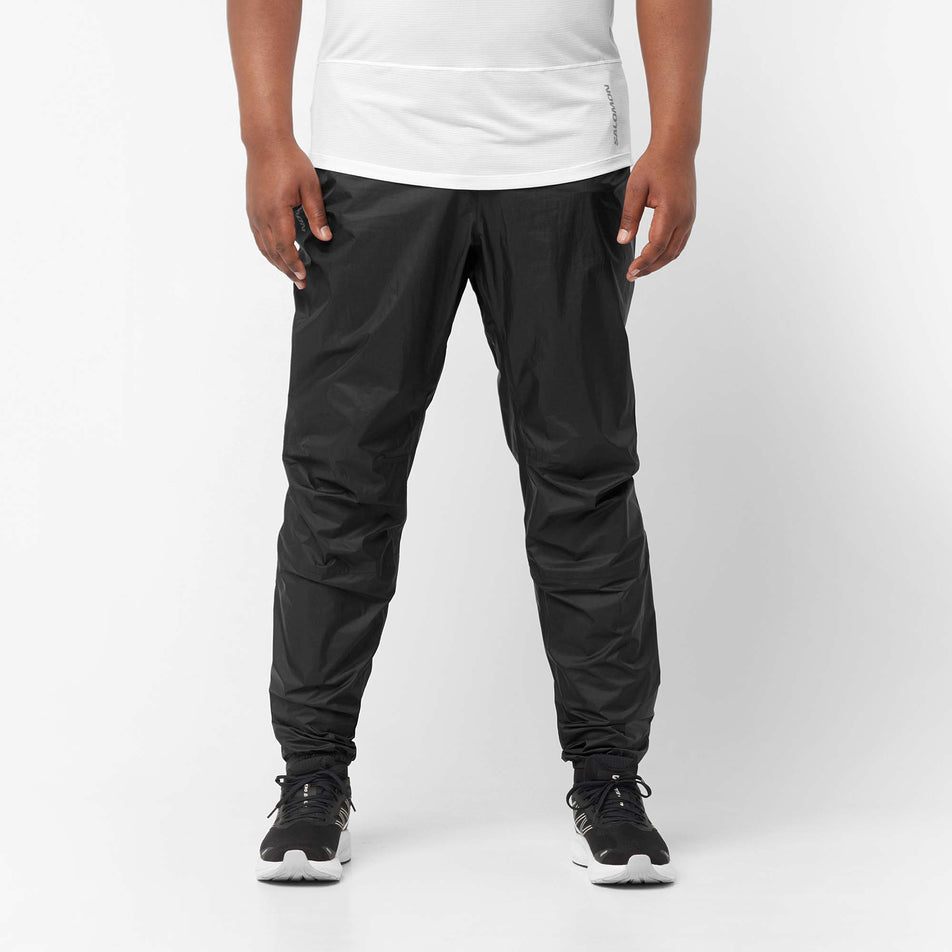 Front view of a model wearing a pair of Salomon Unisex Bonatti Waterproof Pants in the Deep Black colourway (8071099220130)
