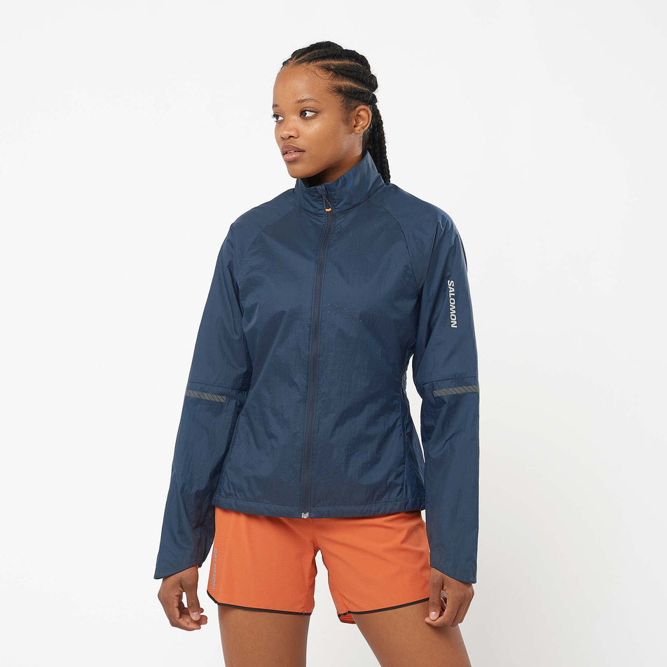 Front view of a model wearing a Salomon Women's Sense Flow Jacket in the Carbon/Carbon colourway. Model is also wearing Salomon running shorts. (8071093649570)