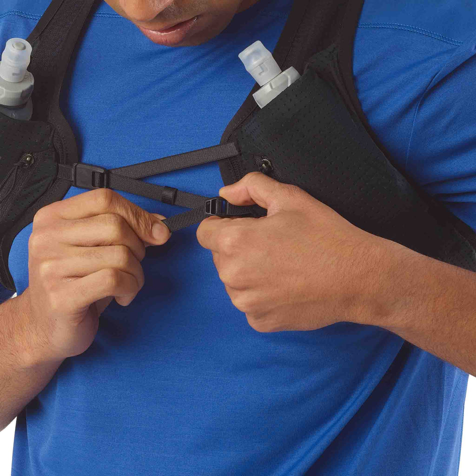 A model demonstrating the fastening system on the front of the Salomon Unisex Pulse 2 Set in the Black colourway.