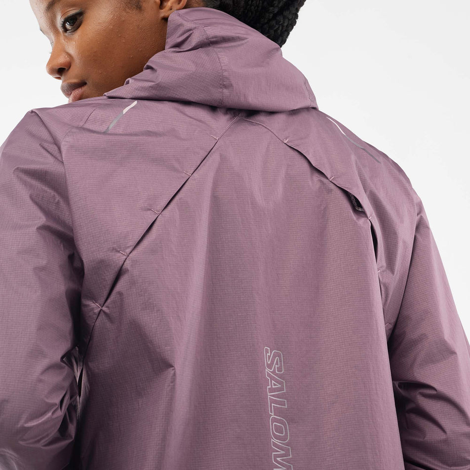 Close-up view of the back of a Salomon Women's Bonatti Waterproof Jacket in the Moonscape colourway, being worn by a model.  (7999026266274)