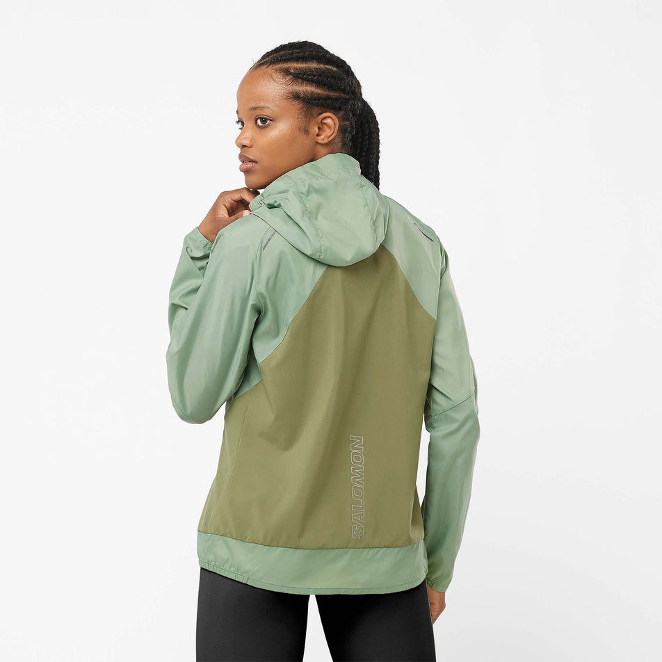 Back view of a model wearing a Salomon Women's Bonatti Cross Wind Jacket in the Lily Pad/Deep Lichen Green colourway (7999055462562)