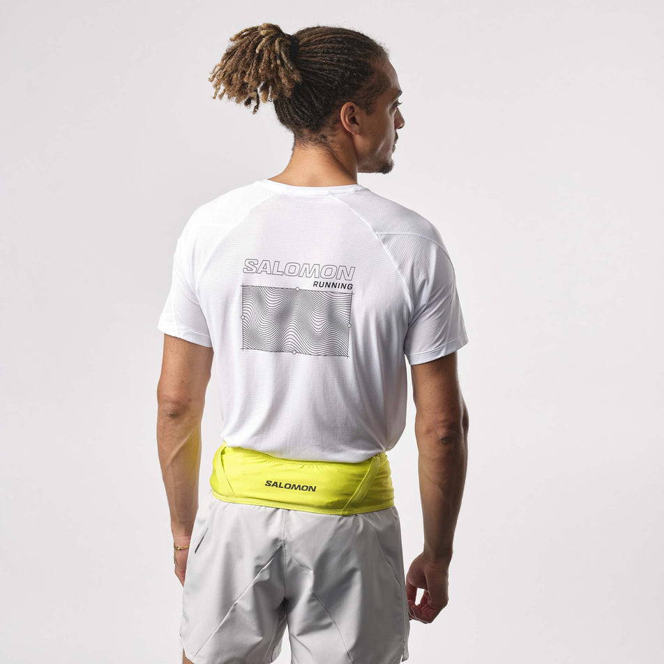 Back view of a model wearing a Salomon Unisex Pulse Belt in the Sulphur Spring colourway. Model is also wearing a running top and running shorts. (8151609639074)
