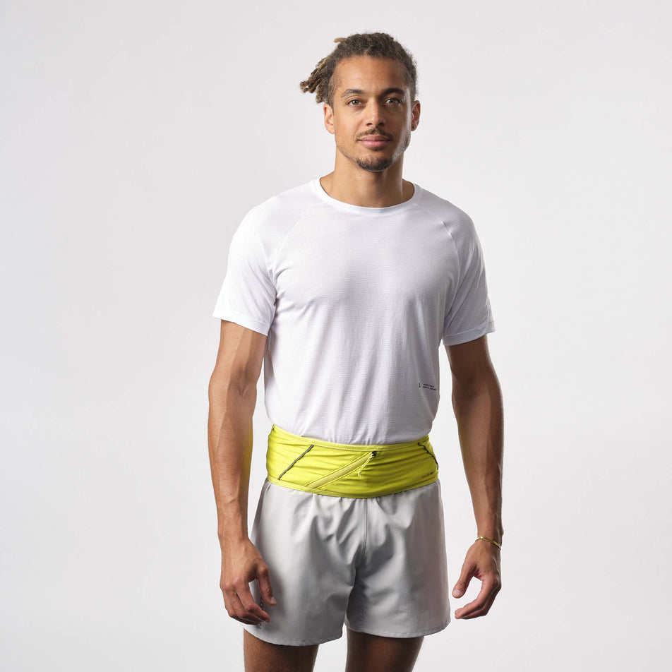 Front view of a model wearing a Salomon Unisex Pulse Belt in the Sulphur Spring colourway. Model is also wearing a running top and running shorts. (8151609639074)