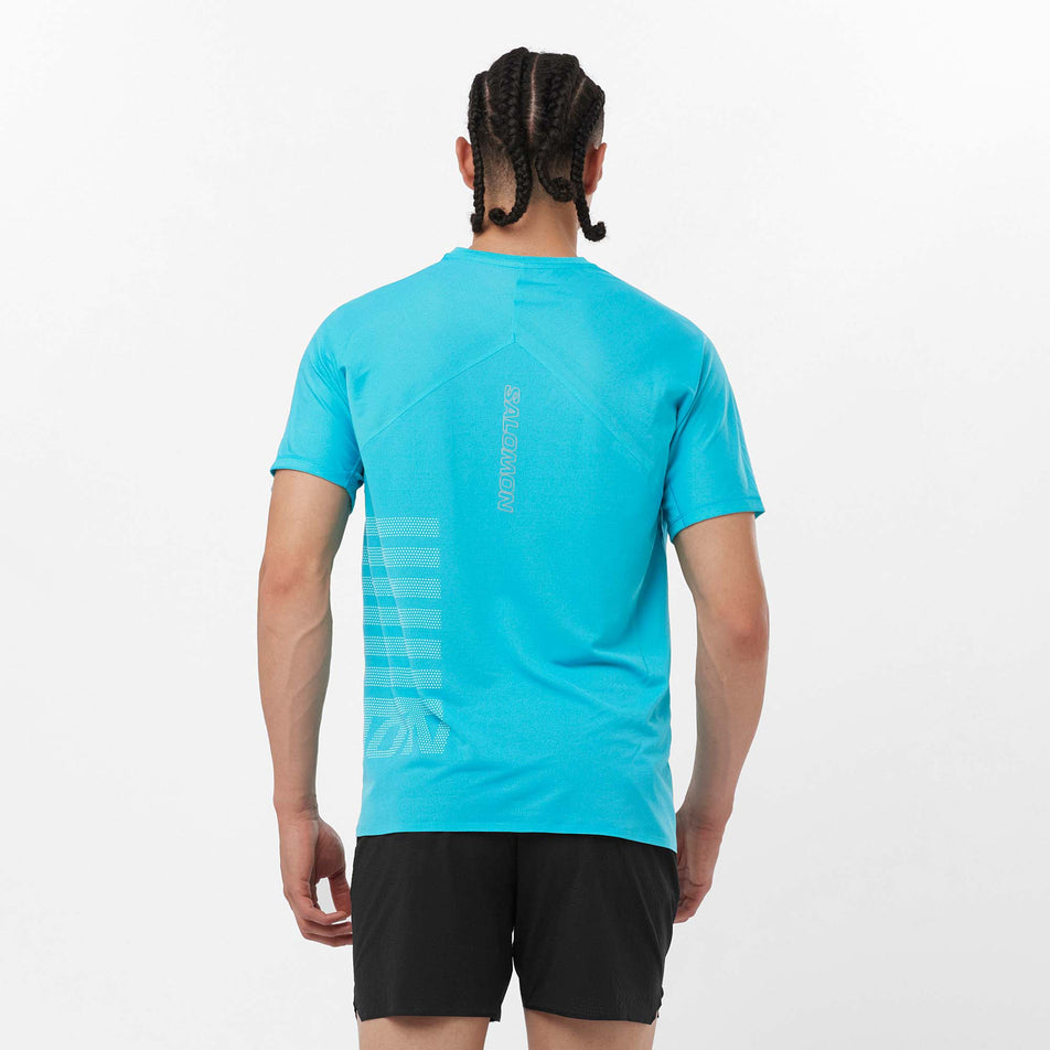 Back view of a model wearing a Salomon Men's Sense Aero GFX Short Sleeve T-Shirt in the Peacock Blue/White colourway. Model is also wearing Salomon shorts. (8157825466530)