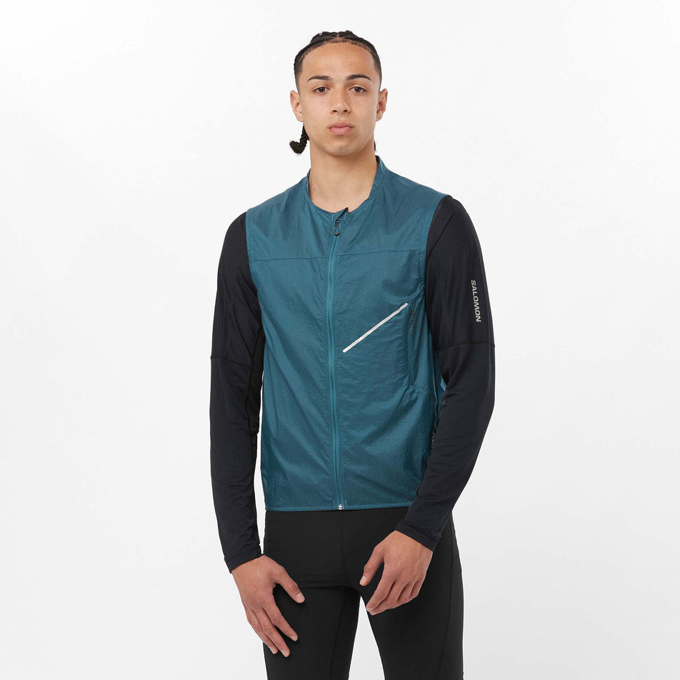 Front view of a model wearing a Salomon Men's Sense Aero Wind Vest in the Deep Dive colourway. Model is also wearing a Salomon long sleeve top and Salomon tights. (8157820977314)