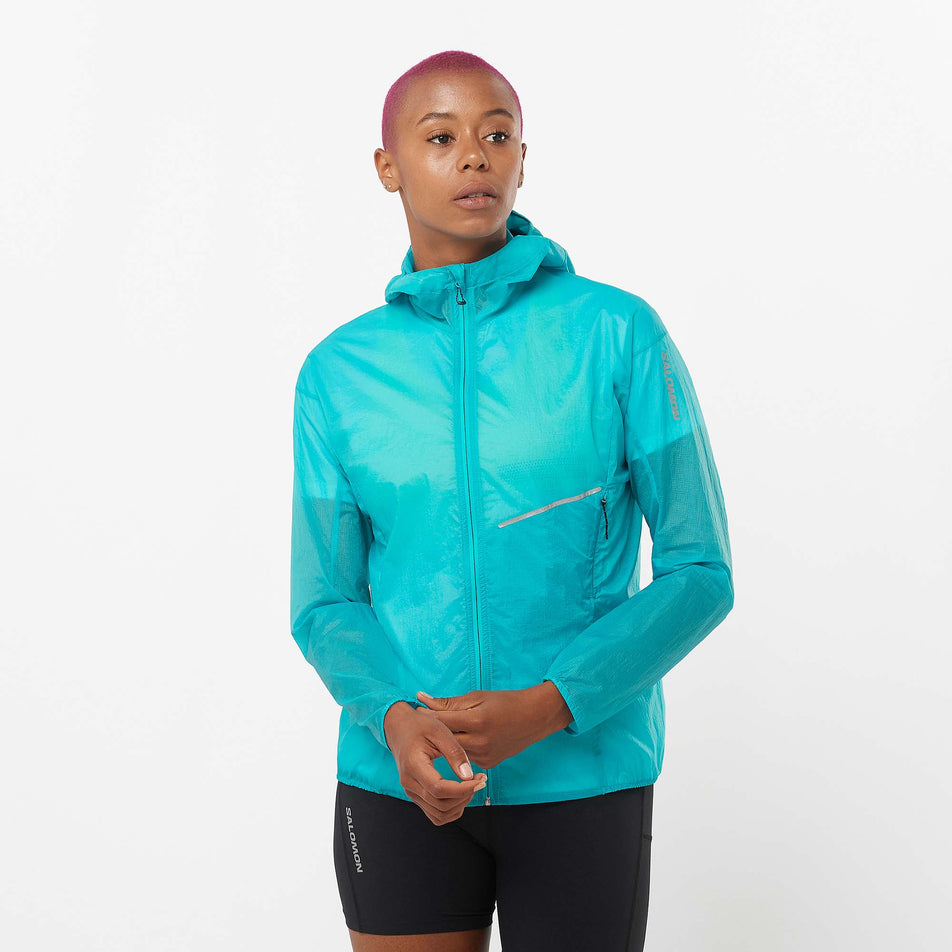 Front view of a model wearing a Salomon Women's Sense Aero Wind Jacket in the Peacoat Blue colourway. Model is also wearing Salomon shorts. (8157861871778)