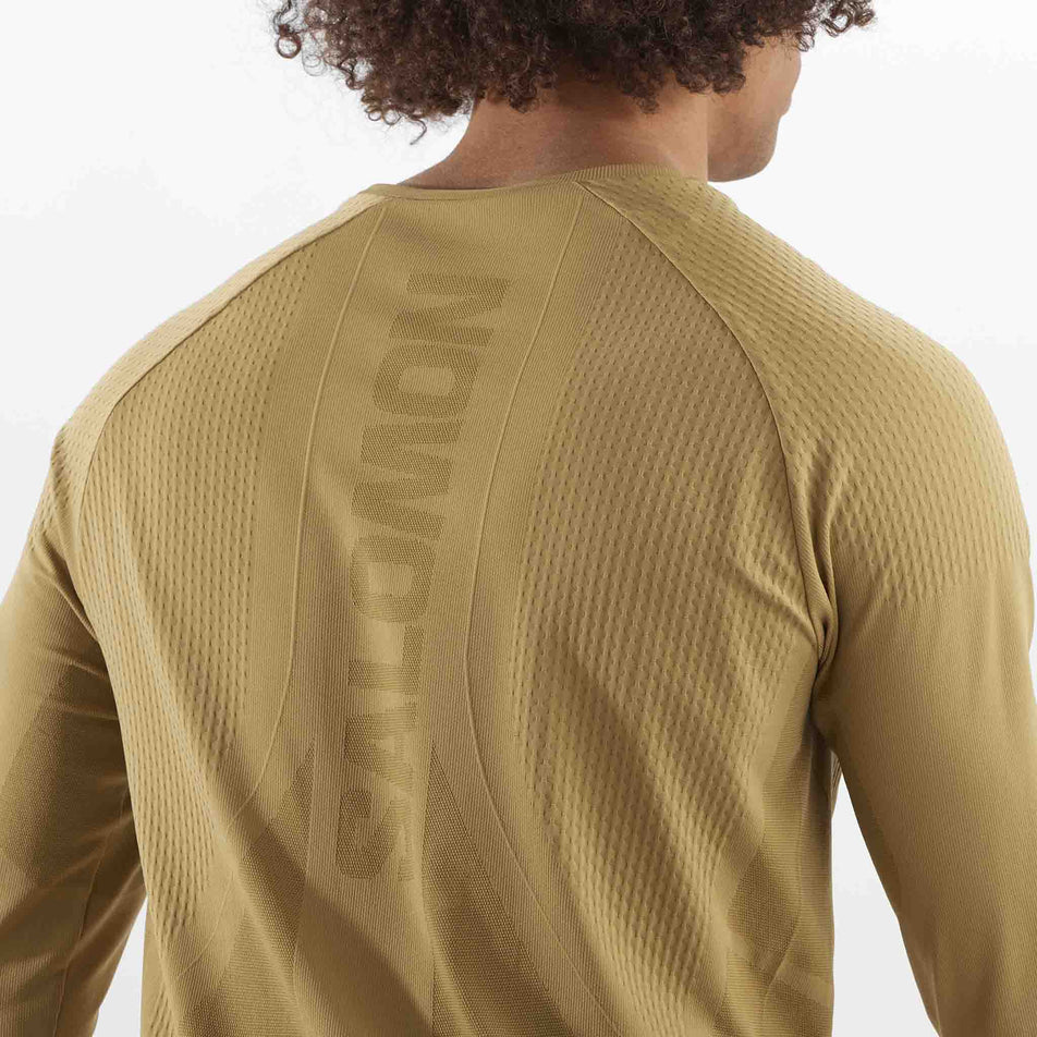 Close-up back view of the Salomon Men's Aero Seamless Long-Sleeve T-Shirt in the Antique Bronze colourway. The top is being worn by a mode. (8509564846242)