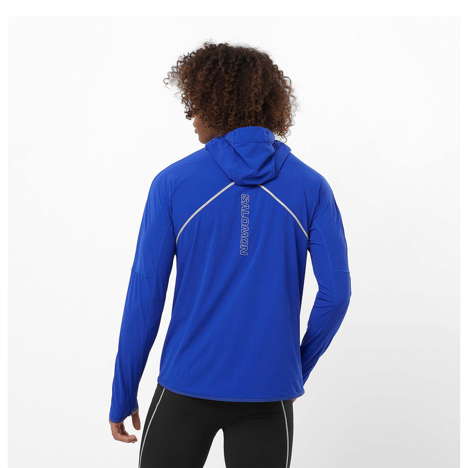 Back view of a model wearing a Salomon Men's Sense Aero Hybrid Midlayer Jacket with hood in the Surf The Web colourway. Model is also wearing legwear. (8464251617442)