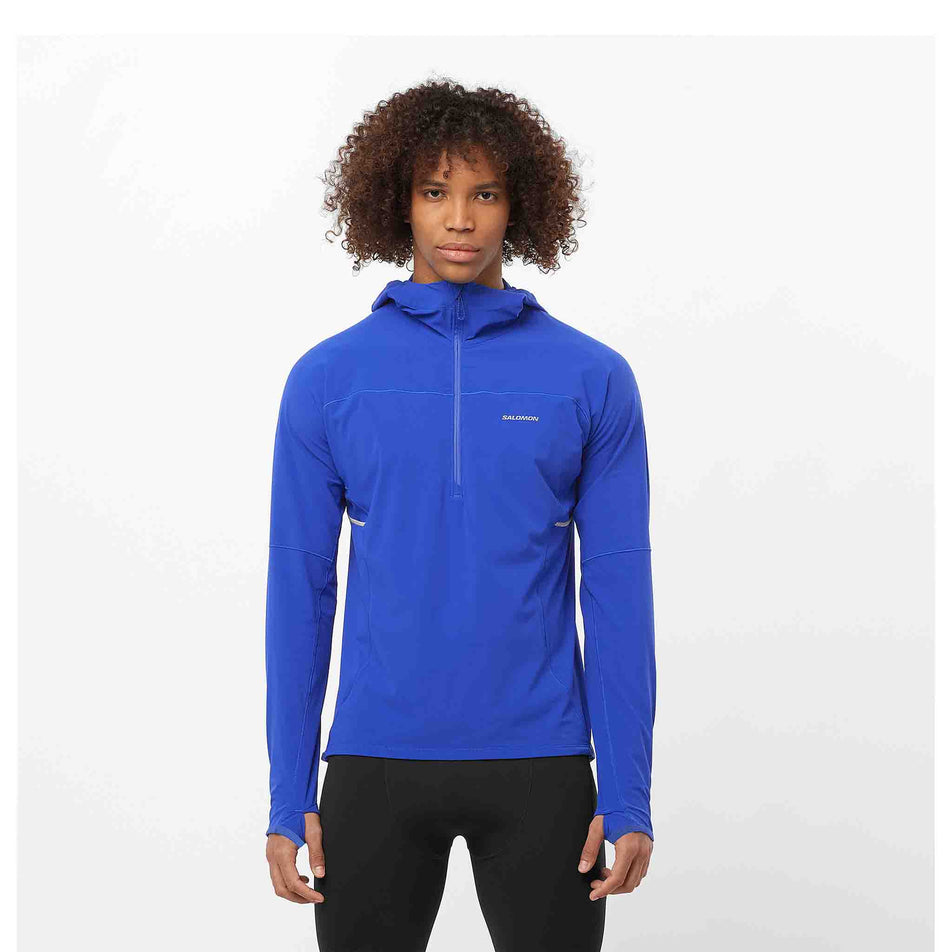 Front view of a model wearing a Salomon Men's Sense Aero Hybrid Midlayer Jacket with hood in the Surf The Web colourway. Model is also wearing legwear. (8464251617442)