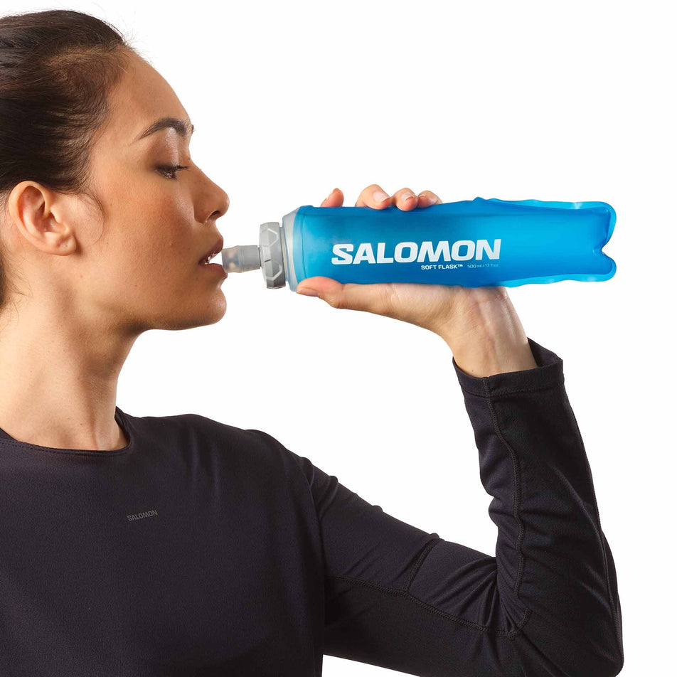 A model drinking from the Salomon Soft Flask 500ml/17oz Ultra 42 in the clear blue colourway. (8575951929506)