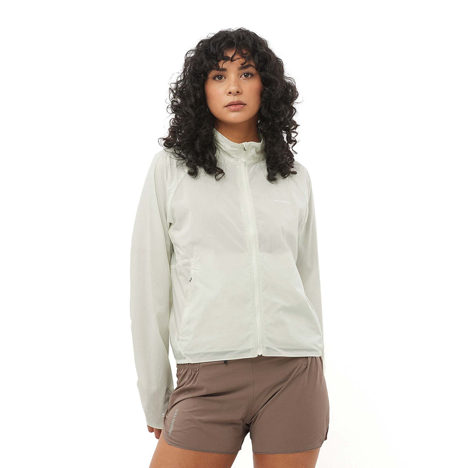 Front view of a model wearing the Salomon Women's SHKout FLY Wind Jacket in the Icicle colourway. (8574551556258)