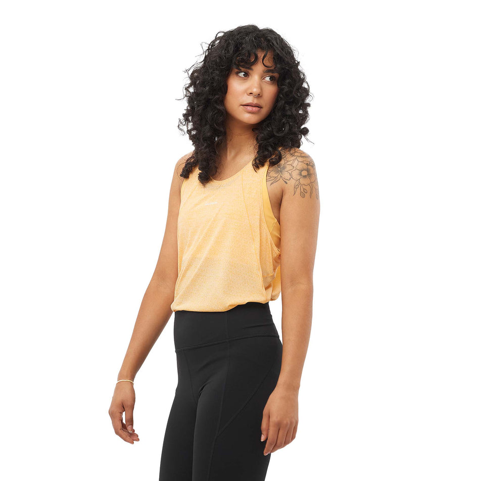 Front view of a model wearing the Salomon Women's SHKout Air Tank in the Warm Apricot colourway. (8577418297506)