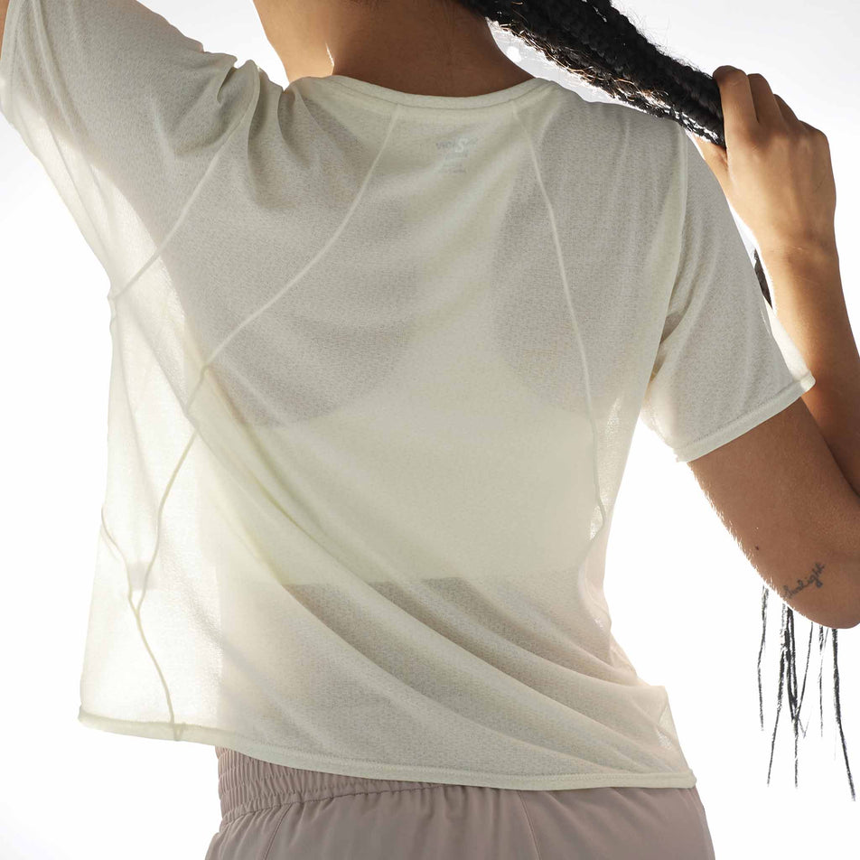 Back view of a model wearing the Salomon Women's SHKout Air Cropped Short Sleeve T-Shirt in the Icicle colourway. (8575548096674)