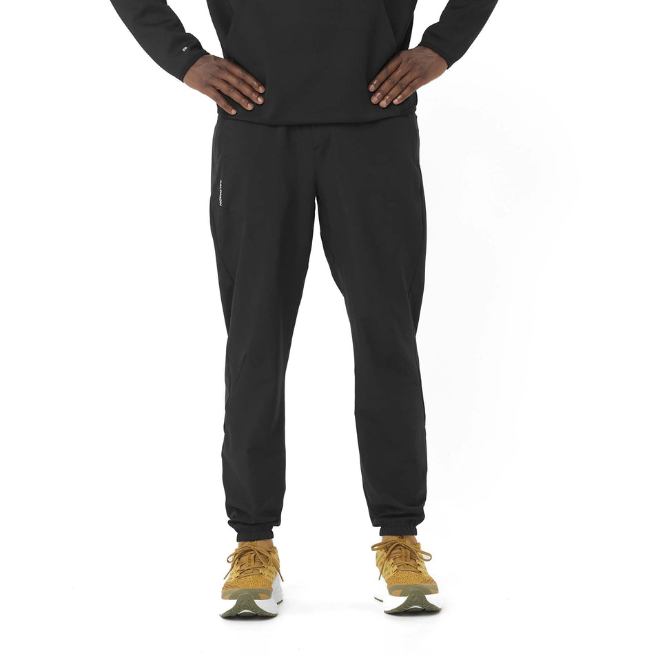 Front view of a model wearing the Salomon Men's SHKout Core Pants in the Deep Black colourway. (8577969291426)