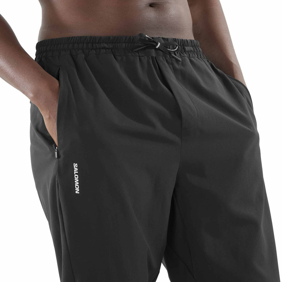 Front view of a model wearing the Salomon Men's SHKout Core Pants in the Deep Black colourway. (8577969291426)