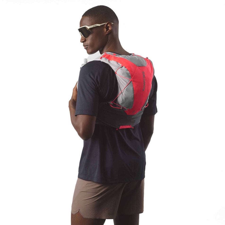 Back view of a model wearing the Salomon Unisex ADV Skin 12 Running Vest with flasks included in the Castlerock/Alloy/Neon Flame colourway. (8575889670306)
