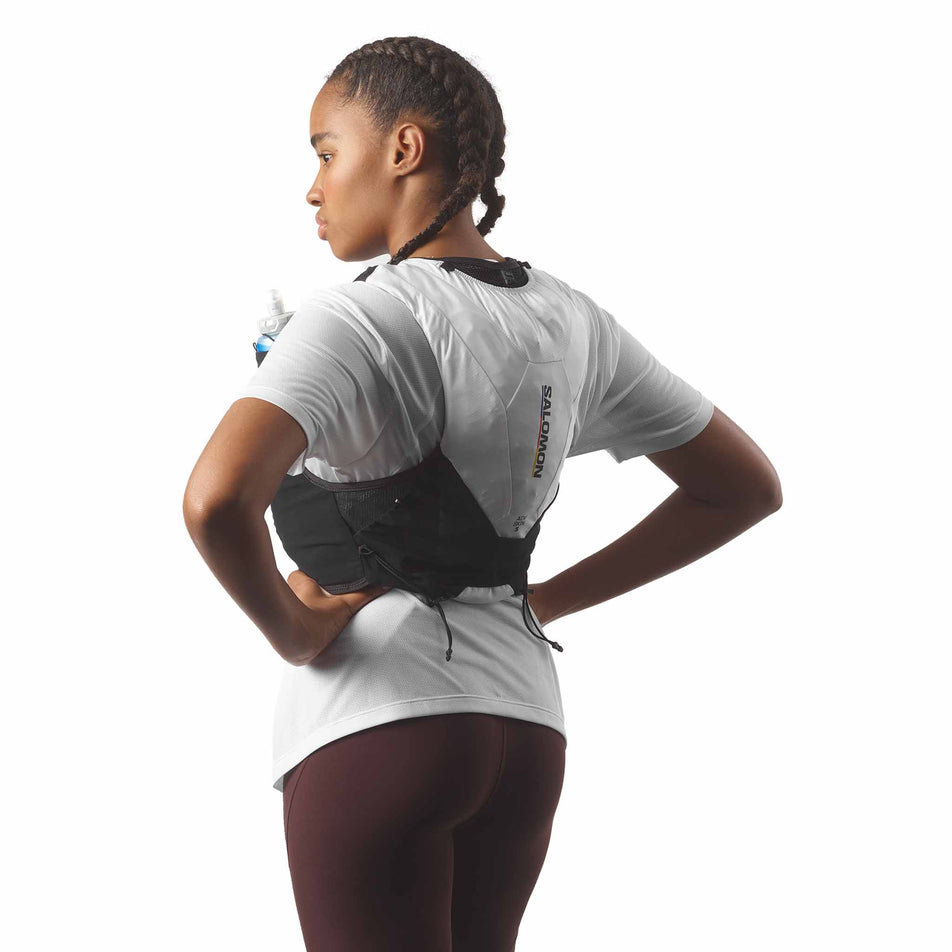 Back view of a model wearing the Salomon Unisex ADV Skin 5 Race Flag Running Vest with flasks included in the Black/White colourway. (8575896682658)