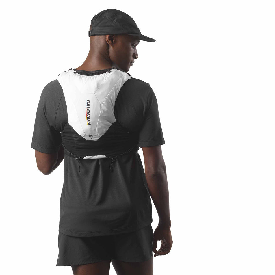 Back view of model wearing the Salomon Unisex ADV Skin 5 Race Flag Running Vest with flasks included in the Black/White colourway. (8575896682658)