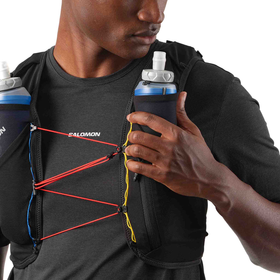 Front view of a model wearing the Salomon Unisex ADV Skin 5 Race Flag Running Vest with flasks included in the Black/White colourway. (8575896682658)