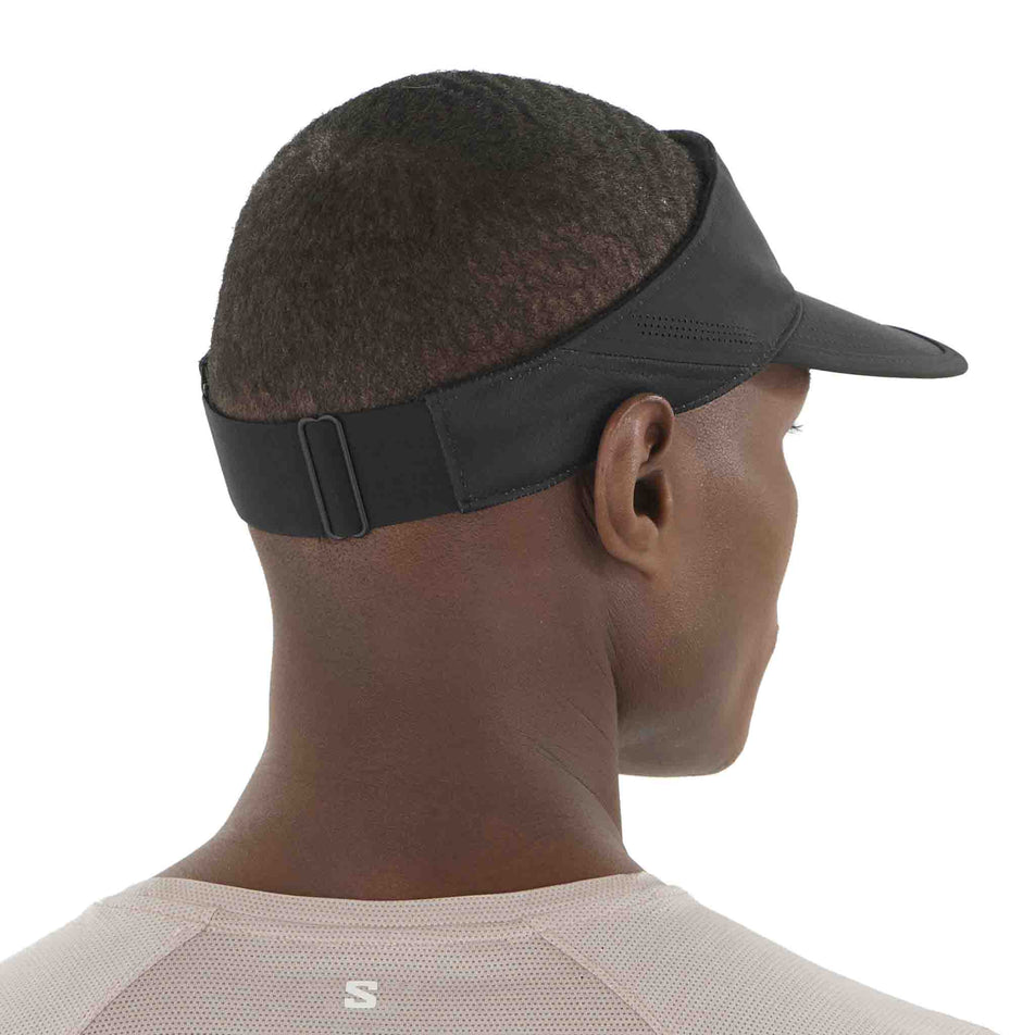 Back view of a model wearing the Salomon Unisex SHKout Visor in the Deep Black colourway. (8577894645922)