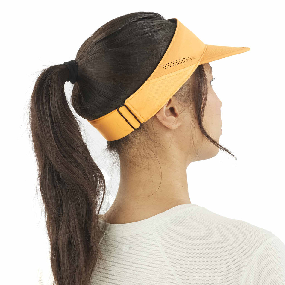Back view of a model wearing the Salomon Unisex SHKout Visor in the Warm Apricot colourway. (8577889108130)