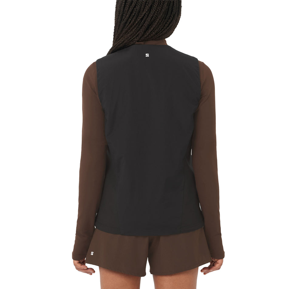 Back view of a model wearing the Salomon Women's Mountain Flex Hybrid Running Vest in the Deep Black colourway. (8781884653730)