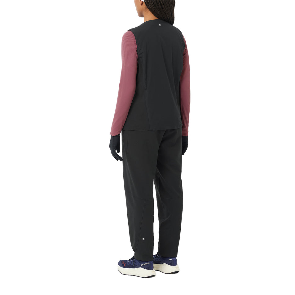 Angled view of a model wearing the Salomon Women's SHAKEout HexaFlow Pants in the Deep Black colourway. (8781921091746)