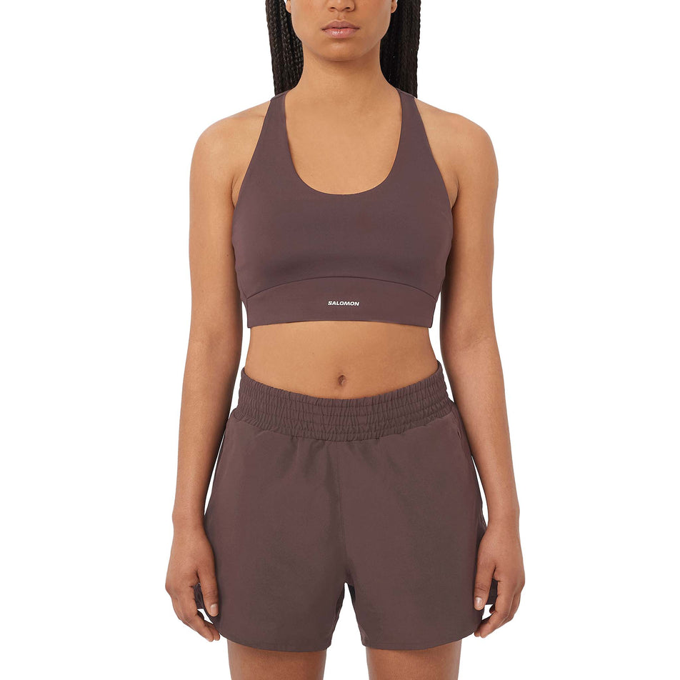 Front view of a model wearing the Salomon Women's SHKout CORE Sports Bra in the Coffee Bean colourway. (8727006281890)