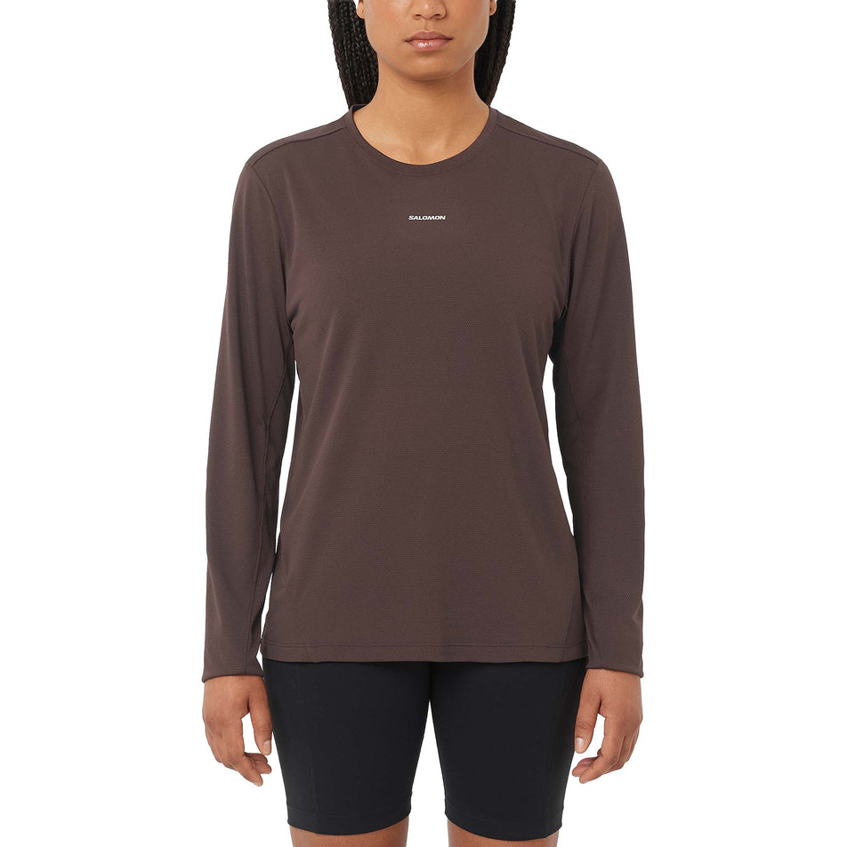 Front view of a model wearing the Salomon Women's SHAKEout Core Long-Sleeve T-Shirt in the Coffee Bean colourway. (8730437714082)