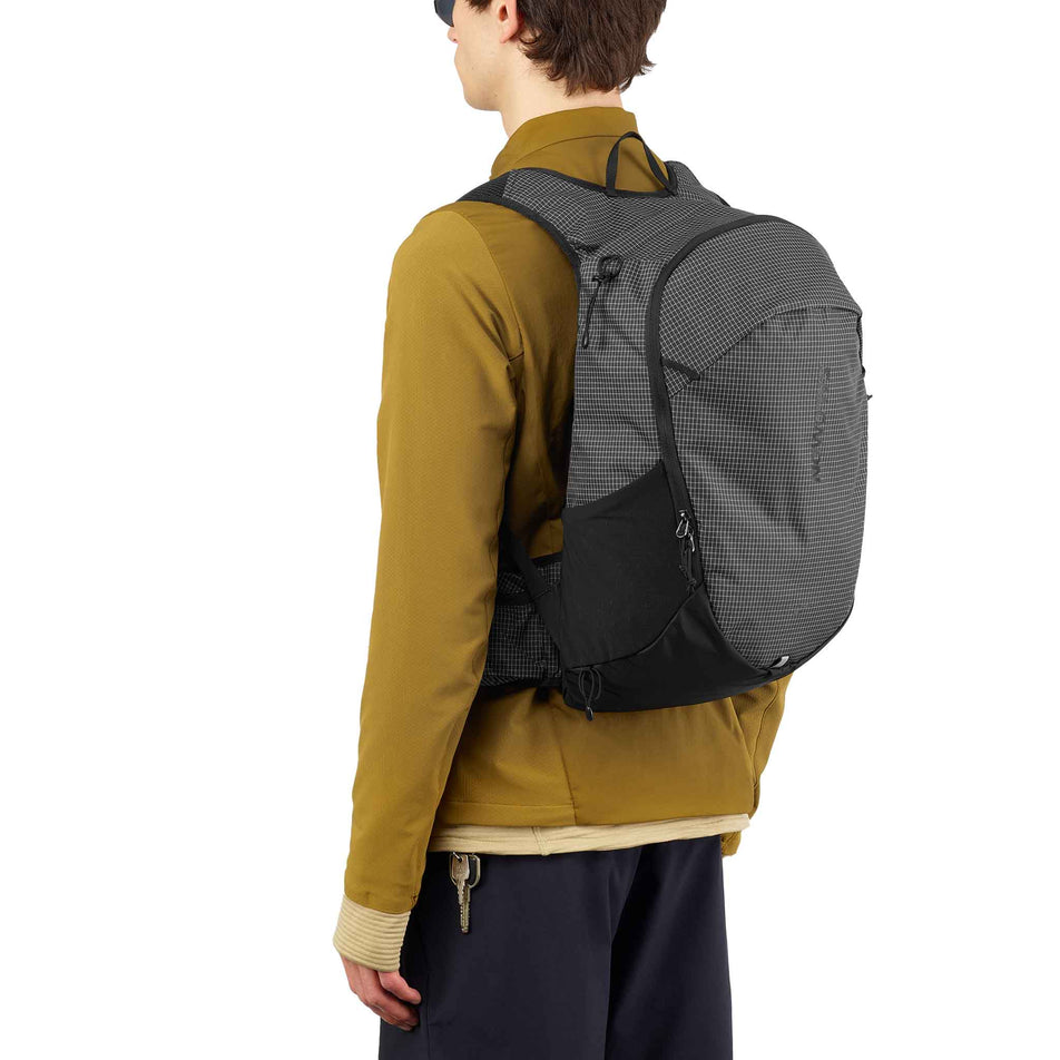 Back view of a model wearing the Salomon Unisex Trailblazer 20 Commuter Bag in the Black/White colourway. (8737342095522)