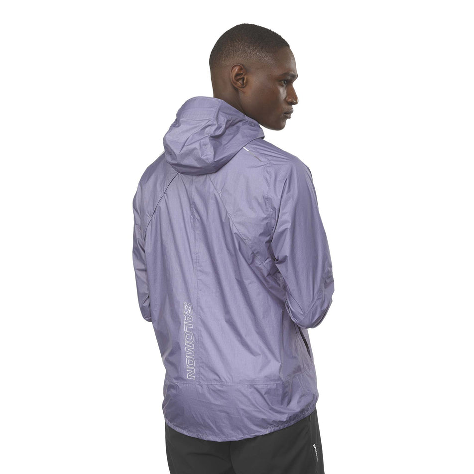 Back view of a model wearing the Salomon Men's Bonatti Waterproof Shell Jacket in the Blue Granite colourway. (8577967095970)