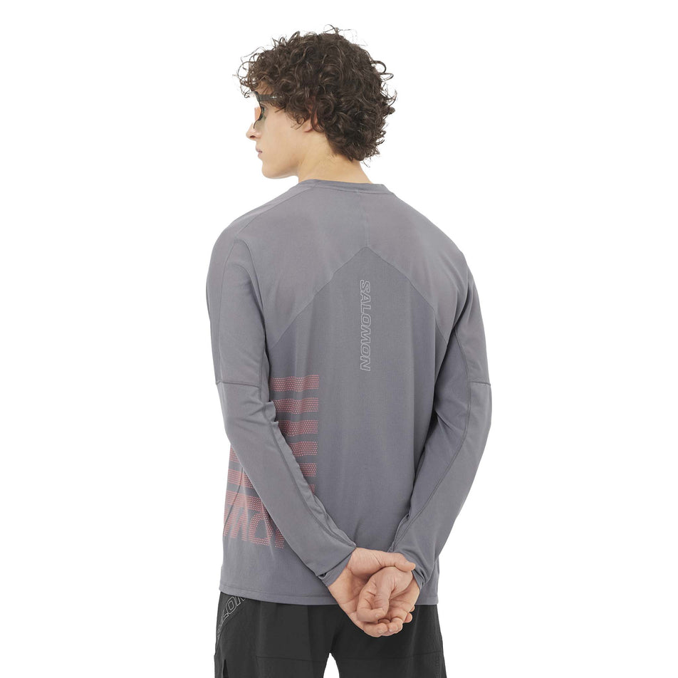 Back view of a model wearing the Salomon Men's Sense Aero Graphic Long Sleeve T-Shirt in the Castlerock/Neon Flame colourway. (8577952907426)
