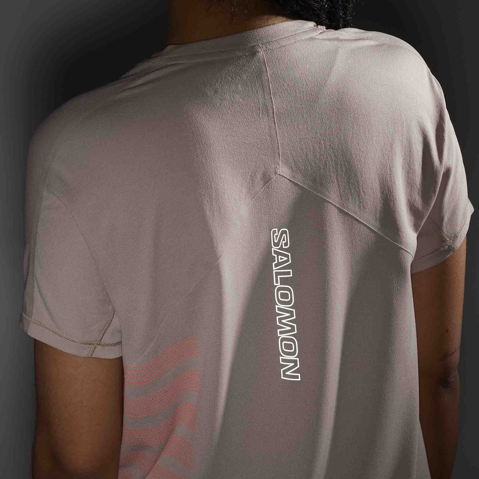 The reflective Salomon logo on the back of the Salomon Sense Aero Graphic Short Sleeve T-Shirt in the Etherea/Neon Flame colourway. (8574203855010)