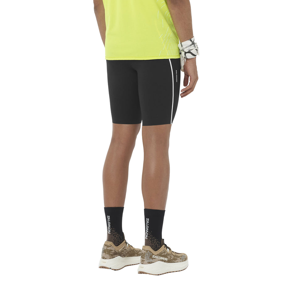 Angled view of a model wearing the Salomon Men's Sense Stow Short Tights 9