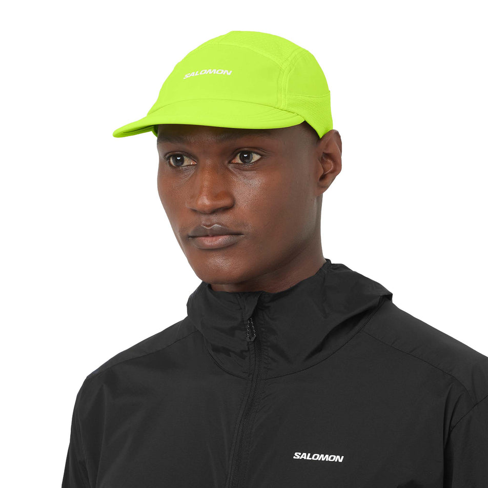 Front view of a model wearing the Salomon Unisex Sense Aero Cap in the Acid Lime colourway.