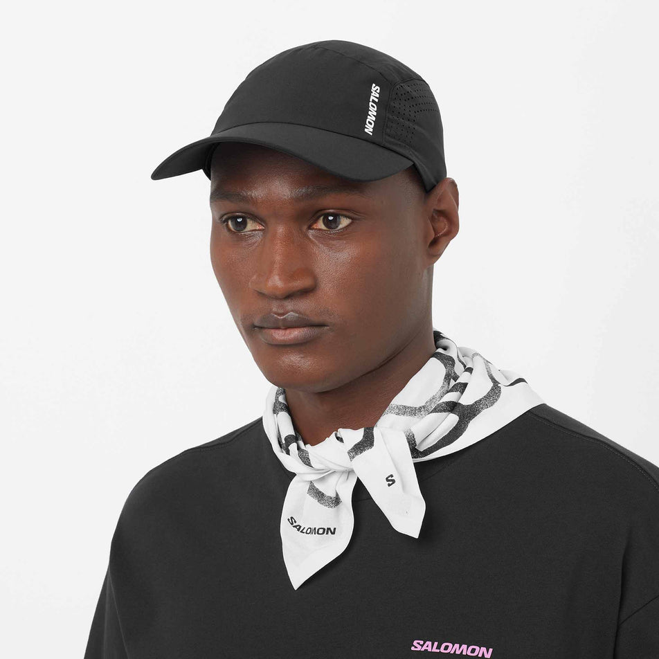 Front view of a model wearing the Salomon Unisex Shakeout Cap in the Deep Black colourway.