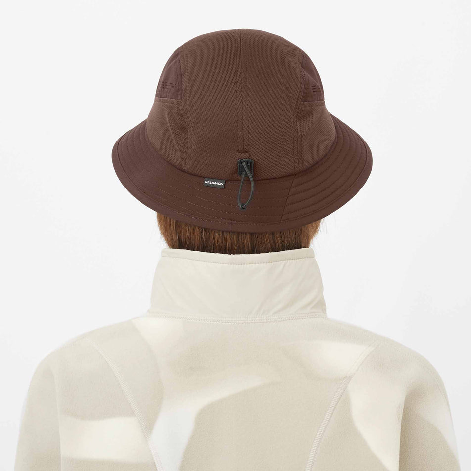 Back view of a model wearing the Salomon Unisex Shakeout Bucket Hat in the Coffee Bean colourway.