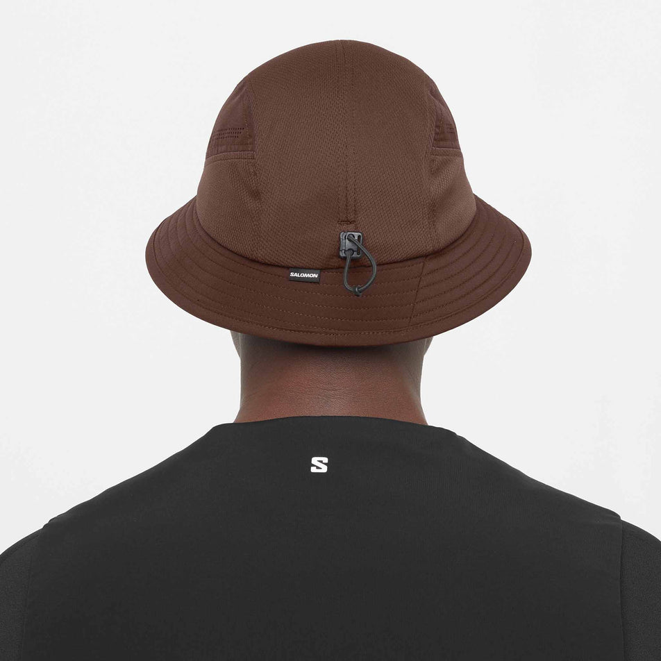 Back view of a model wearing the Salomon Unisex Shakeout Bucket Hat in the Coffee Bean colourway.