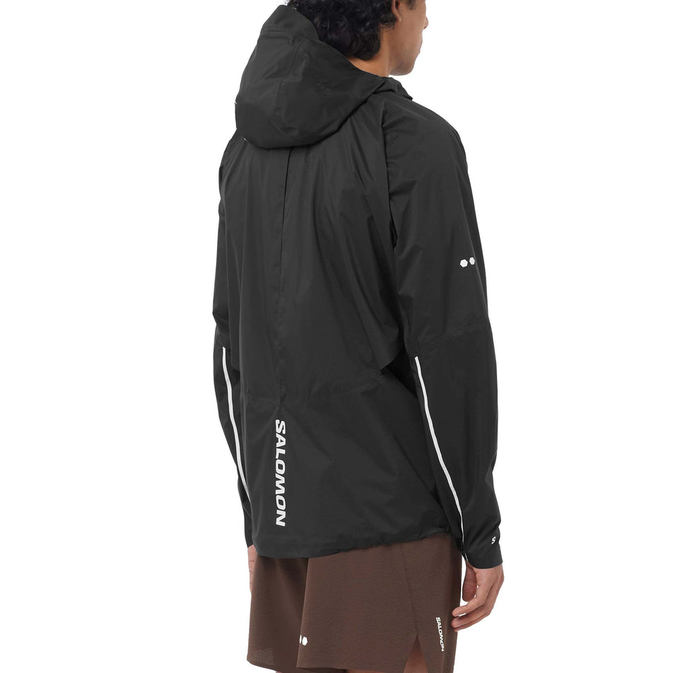 Angled view of a model wearing the Salomon Men's Bonatti Pro Shell Jacket in the Deep Black colourway.