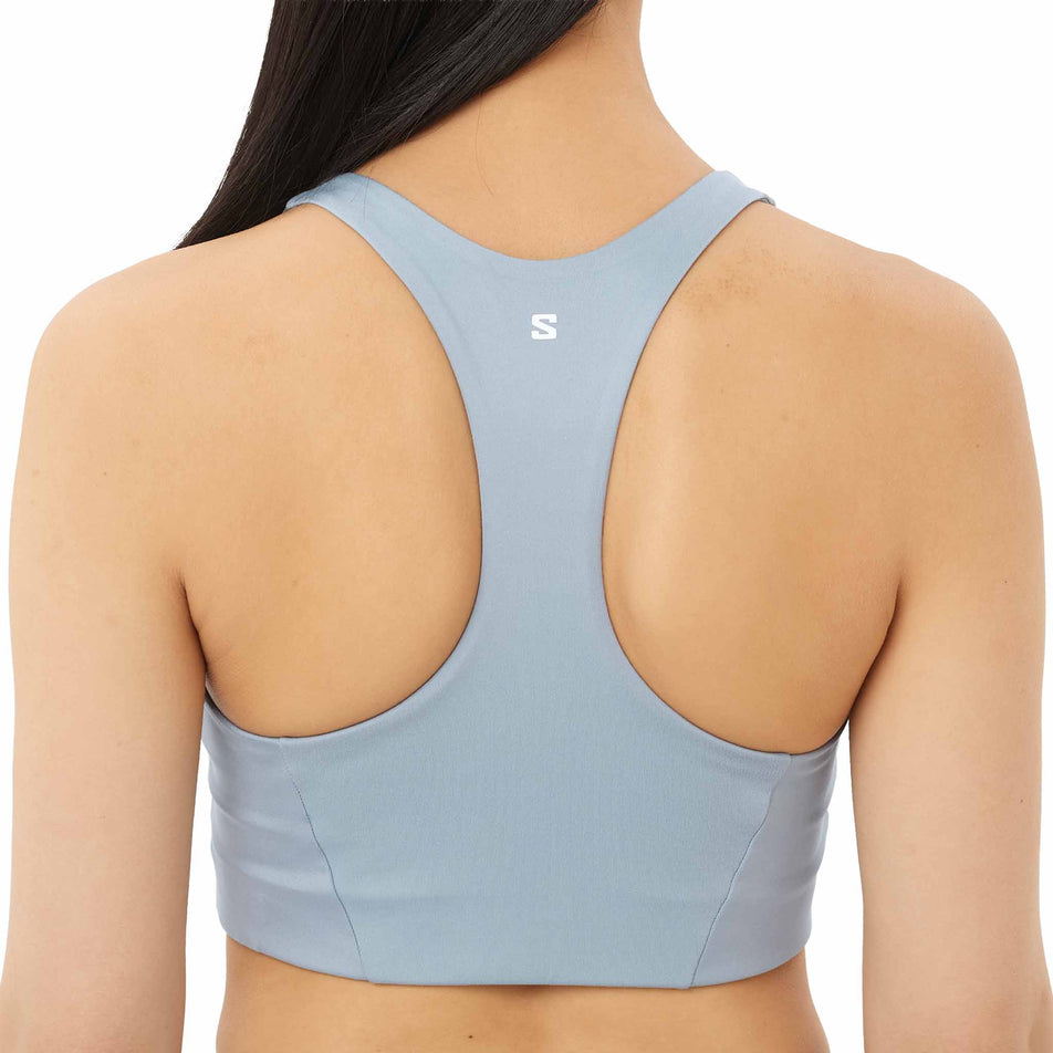 Back view of a model wearing the Salomon Women's SHKout CORE Sports Bra in the Trade Winds colourway.