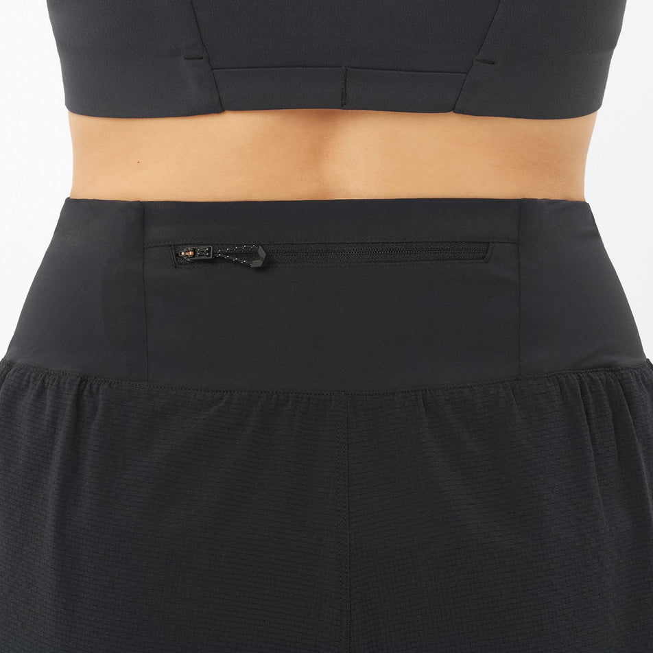 The zip pocket on the back of a model wearing the Salomon Women's Sense Aero 4