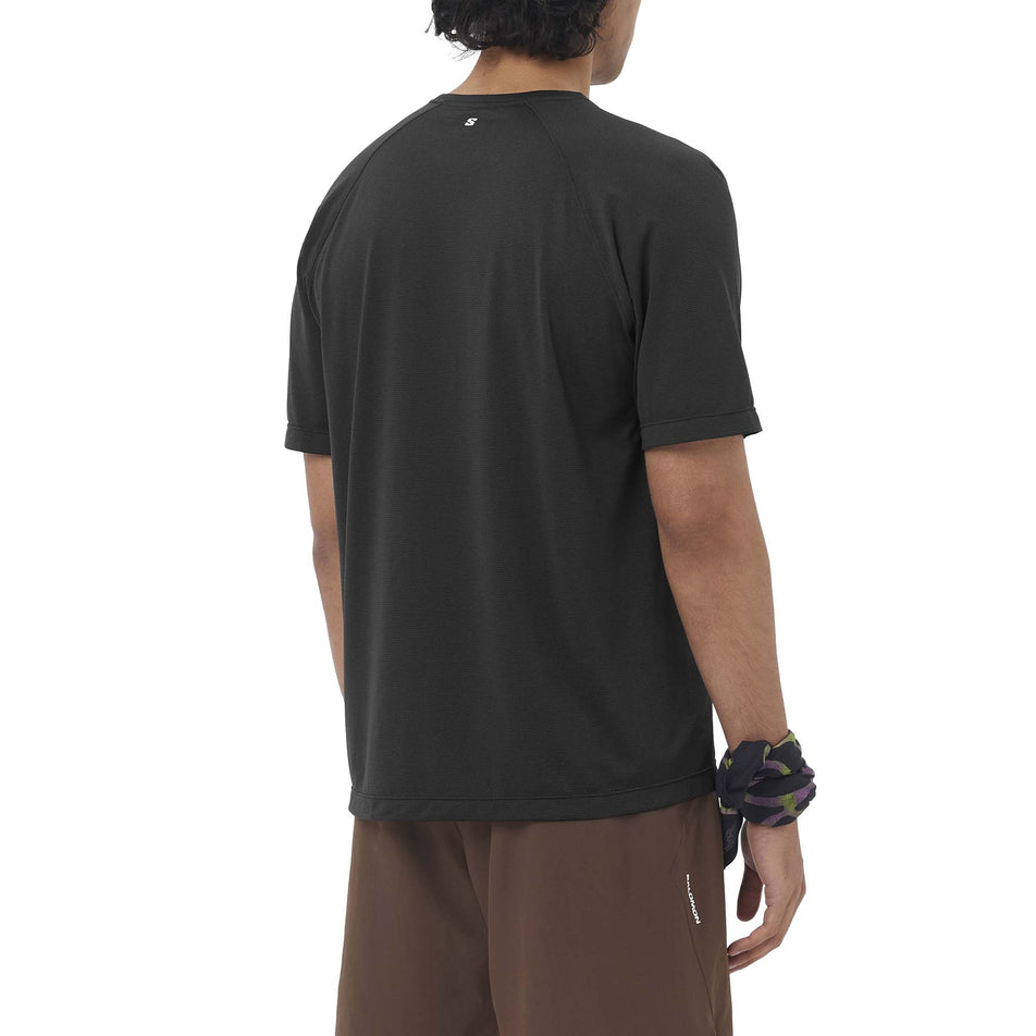 Back view of a model wearing the Salomon Men's SHKout Core SS Tee GFX in the Deep Black colourway.