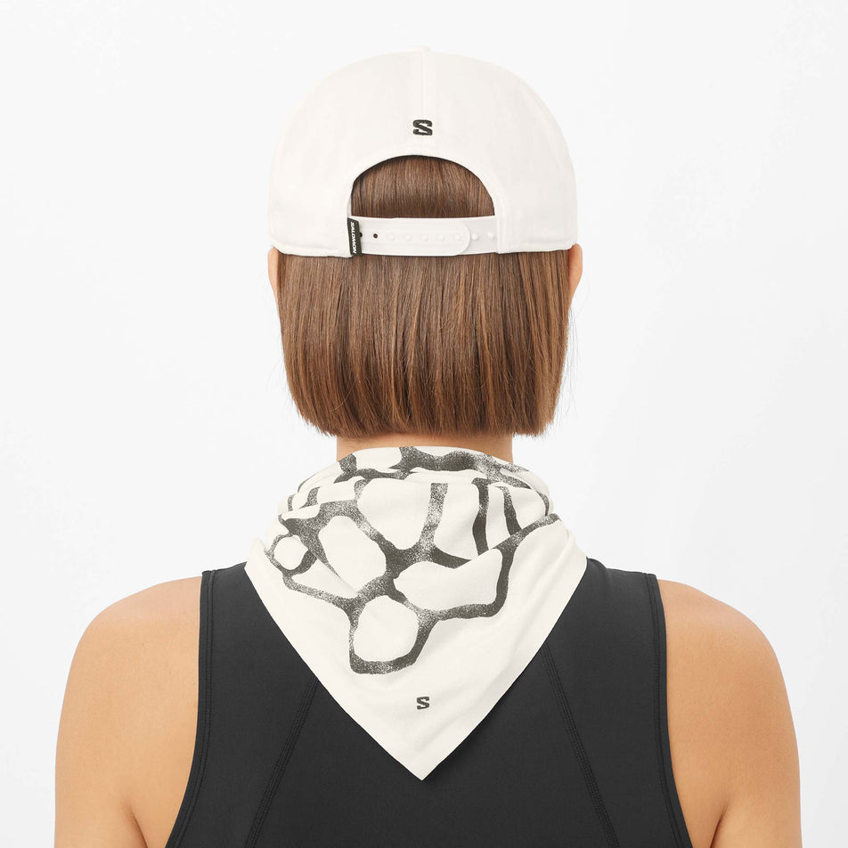 Back view of a model wearing the Salomon Unisex Logo Flat Cap in the Whisper White colourway.