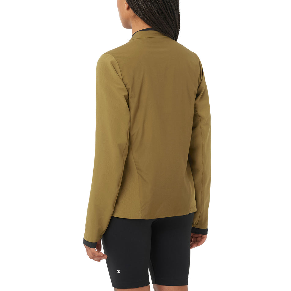 Back view of a model wearing the Salomon Women's Mountain Flex Hybrid Insulated Jacket in the Brilliant Olive colourway