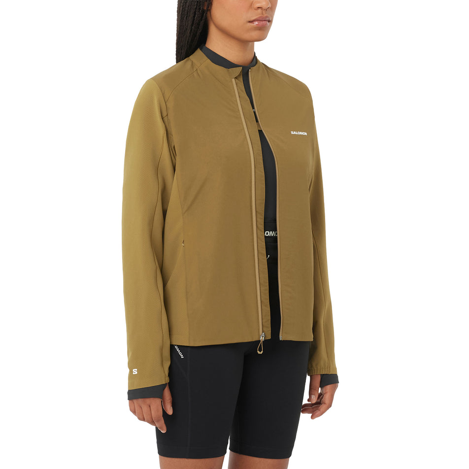 Front view of a model wearing the Salomon Women's Mountain Flex Hybrid Insulated Jacket in the Brilliant Olive colourway.