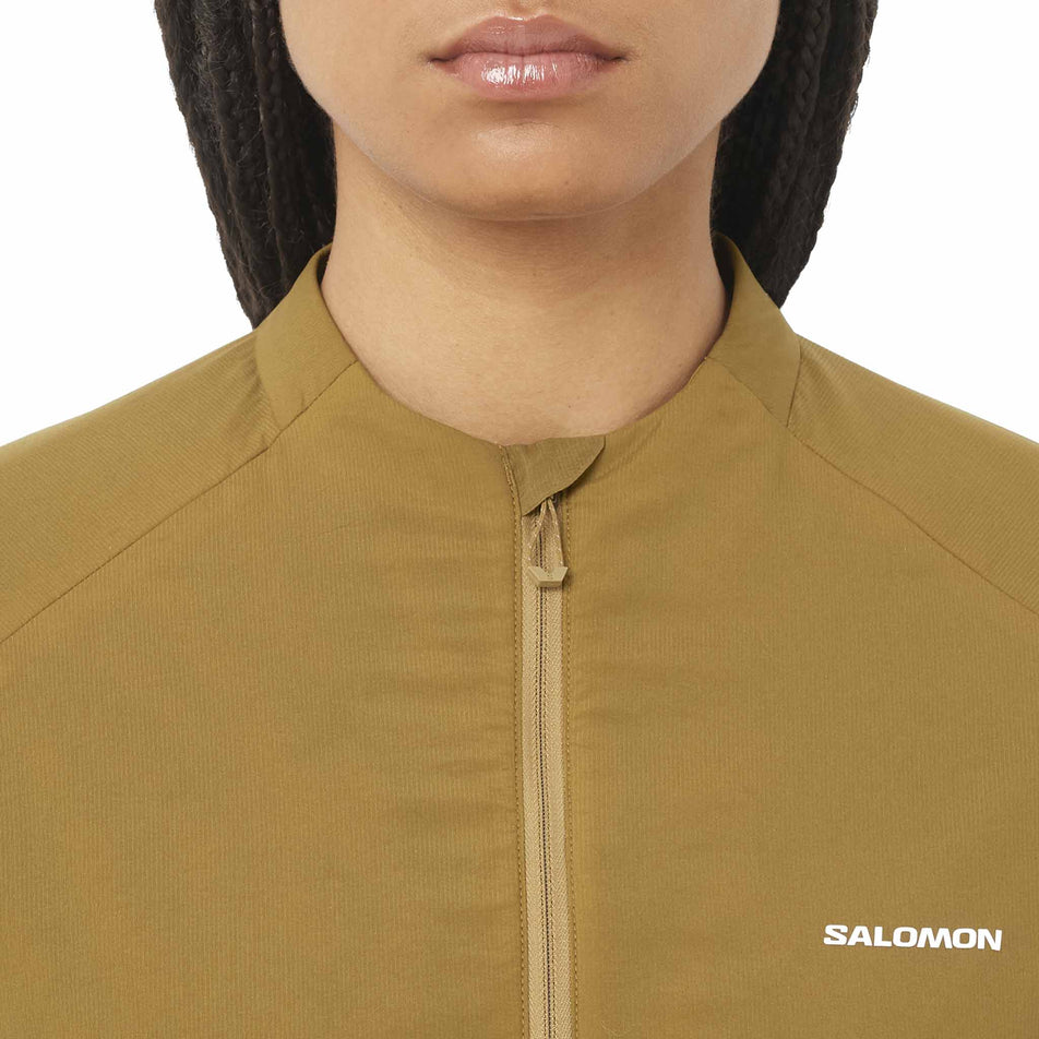 Front view of a model wearing the Salomon Women's Mountain Flex Hybrid Insulated Jacket in the Brilliant Olive colourway