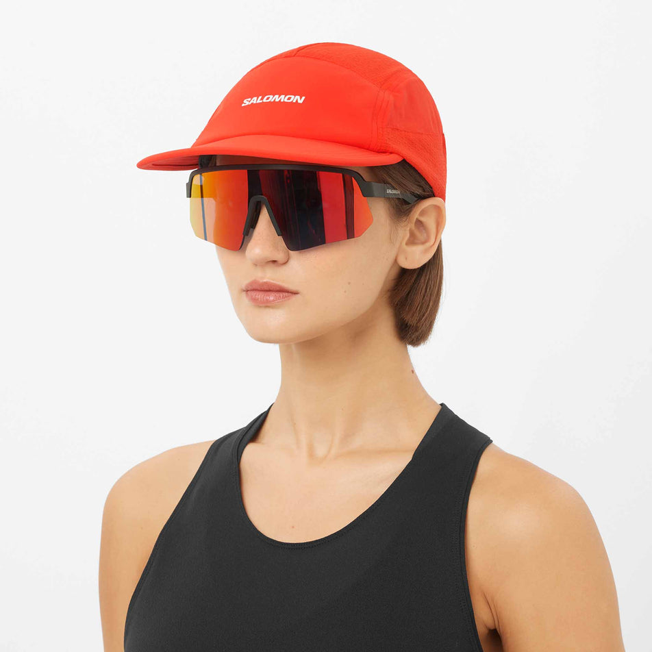 Front view of a model wearing the Salomon Unisex Sense Aero Cap in the Fiery Red colourway.